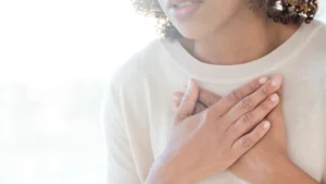 A woman holds her hands over her chest during anxiety